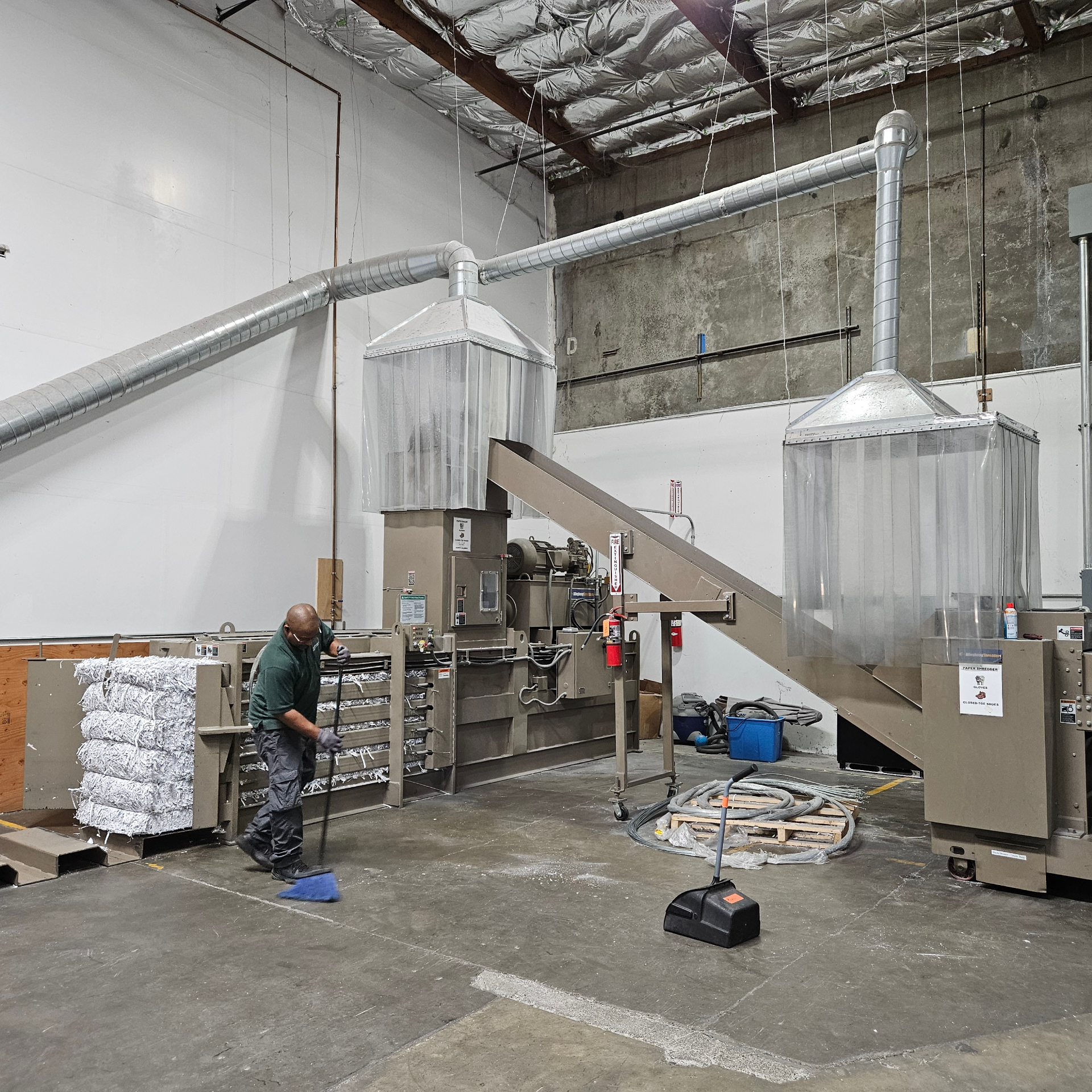 UCPNB team member operating the secure paper shredding and baling equipment in the fulfillment warehouse