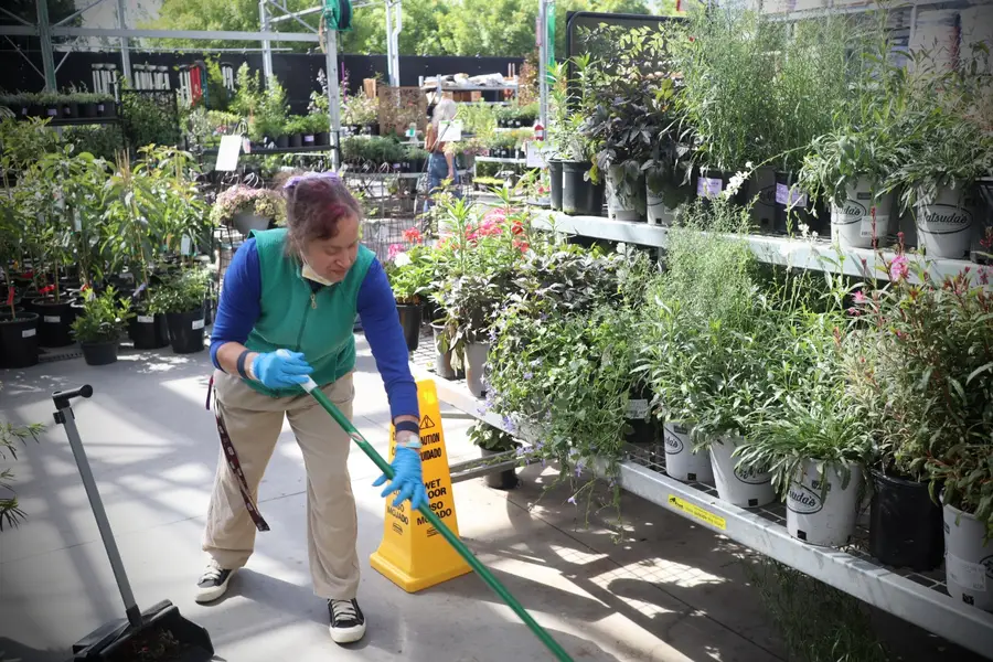 UCPNB supported employee sweeping at a garden center nursery
